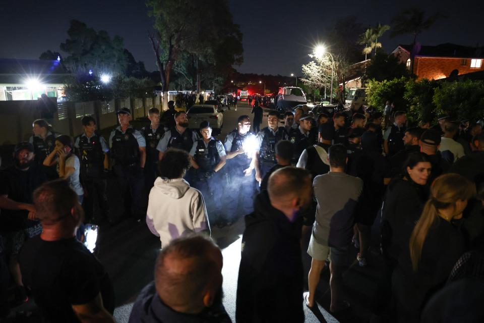 Locals gather with police guarding the perimeter of the Christ the Good Shepherd Church in Sydney (AFP via Getty Images)