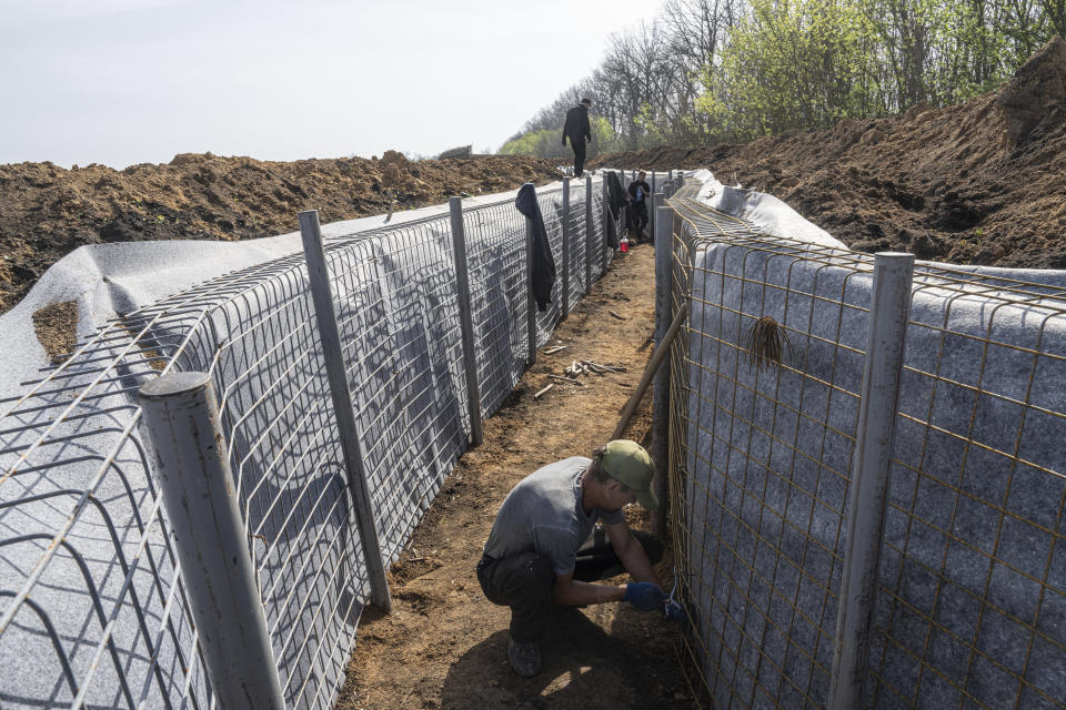 Workers construct new defensive positions close to the Russian border in Kharkiv region, Ukraine, on Wednesday, April 17, 2024. (AP Photo/Evgeniy Maloletka)