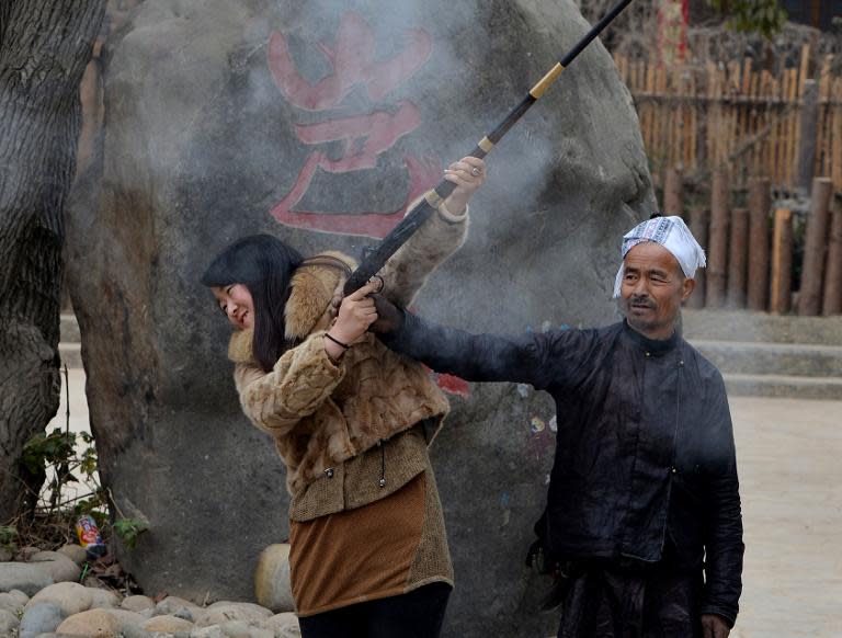 A tourist fires a rifle belonging to members of the Miao ethnic group in Biasha Village, Guizhou Province on February 4, 2014