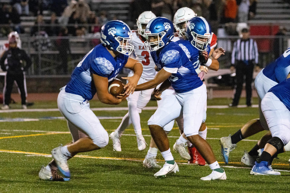 Pleasant Valley's Valentino Byers-Robinson (10) hands it off to Alexander Ecker (30) at the battle of Old Oaken Bucket on Friday, Oct 20, 2023