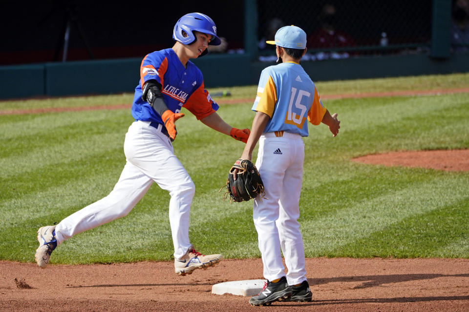 Taylor, Mich.'s Cameron Thorning, left, is greeted by Honolulu, Hawaii shortstop Kekoa Payanal (15) as he rounds second after hitting a two-run home run off starting pitcher Micah Bennett during the first inning of a baseball game at the Little League World Series in South Williamsport, Pa., Saturday, Aug. 28, 2021. (AP Photo/Tom E. Puskar)