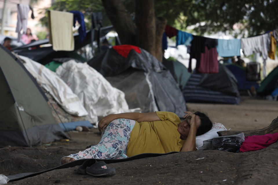 A migrant woman rests at a tent camp as she waits for a Honduras Migration transit permit to continue her way north to Guatemala, and hopefully make it to the Mexico-United States border, in Danlí, Honduras, Wednesday, Oct. 11, 2023. According to Honduras' immigration agency, at the country's southern border with Nicaragua, more than 18,300 migrants entered the town last week. (AP Photo/Elmer Martinez)