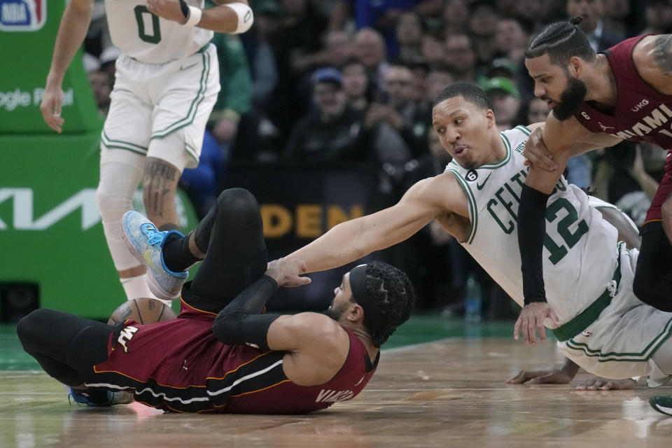 Miami Heat guard Gabe Vincent, front left, tries to hold onto the ball next to Boston Celtics forward Grant Williams (12) during the second half of Game 2 of the NBA basketball playoffs Eastern Conference finals in Boston, Friday, May 19, 2023. (AP Photo/Charles Krupa)