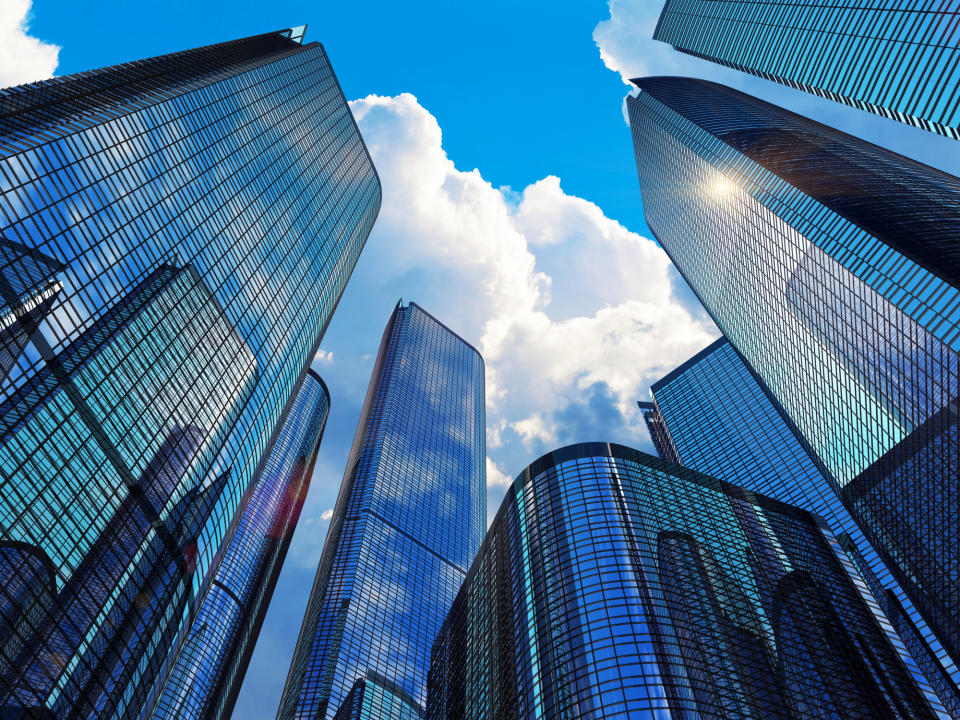 A group of skyscrapers against a sunny sky.