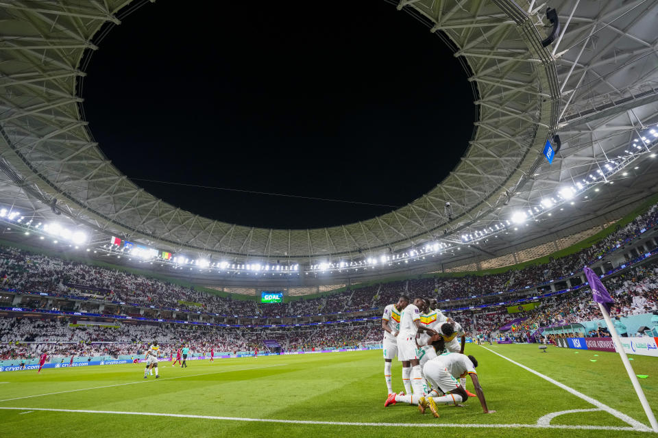 Temmates celebrate with Senegal's Bamba Dieng after he scored their third goal against Qatar during a World Cup group A soccer match at the Al Thumama Stadium in Doha, Qatar, Friday, Nov. 25, 2022. (AP Photo/Petr Josek)