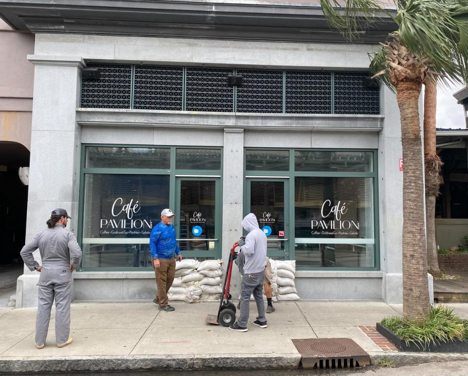 Businesses in Charleston, SC put sandbags in front of their stores on Thursday to prepare for Hurricane Ian (Richard Hall/The Independent)