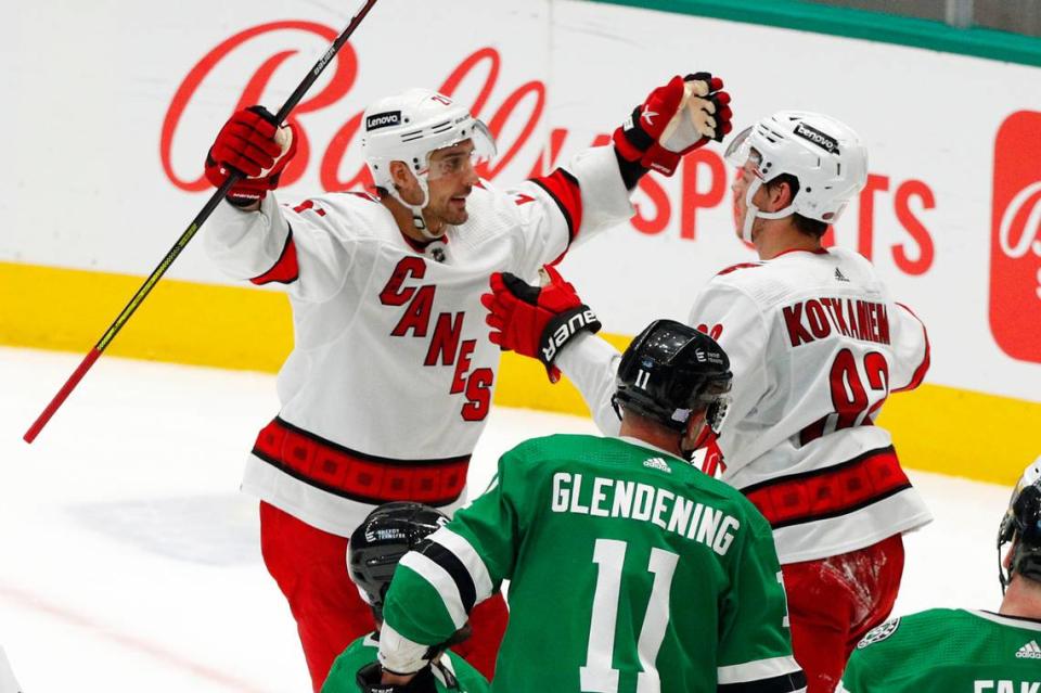 Carolina Hurricanes right wing Nino Niederreiter (21) and center Jesperi Kotkaniemi (82) celebrate a goal against the Dallas Stars during the third period of an NHL hockey game Tuesday, Nov. 30, 2021, in Dallas. (AP Photo/Richard W. Rodriguez)