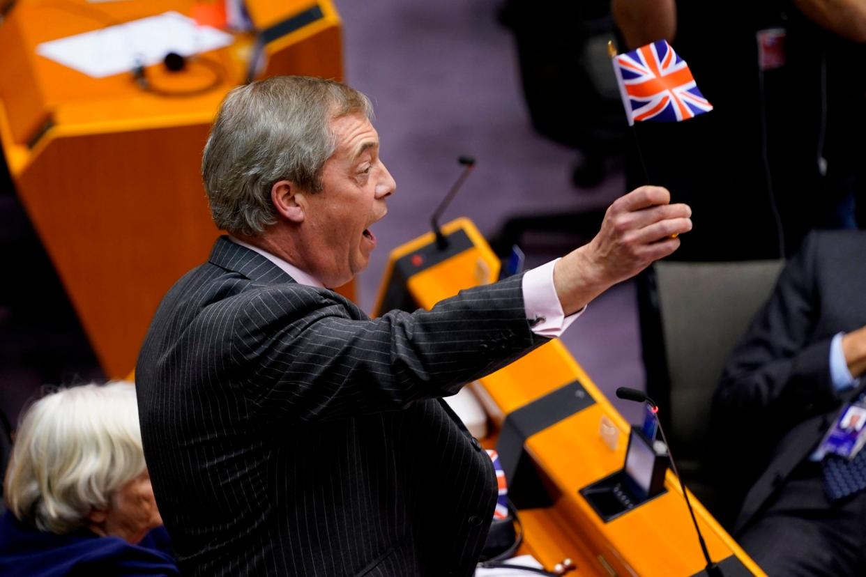 Britain's Brexit Party leader Nigel Farage (C) waves a union flag during the European Parliament plenary session: AFP via Getty Images