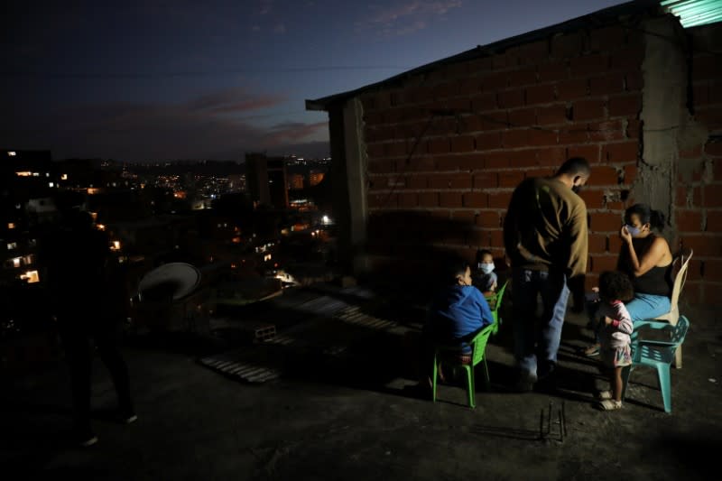 A family watch a movie projected on a giant screen in the low-income neighborhood of Petare, amid the coronavirus disease (COVID-19) outbreak in Caracas