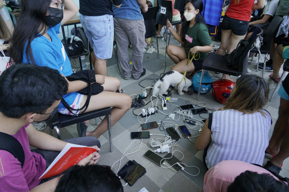 Residents charge their phones for free at a mall as most parts of Cebu city, central Philippines, remain without electricity due to Typhoon Rai on Saturday, Dec. 18, 2021. The strong typhoon engulfed villages in floods that trapped residents on roofs, toppled trees and knocked out power in southern and central island provinces, where more than 300,000 villagers had fled to safety before the onslaught, officials said. (AP Photo/Jay Labra)