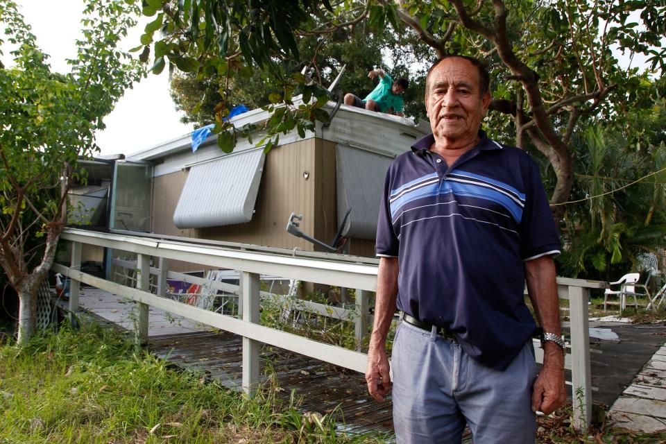 Francisco Flores, who has lived in Citrus Park Village for 20 years with his wife, stands in front of his home as his son repairs his roof on Tuesday, Oct. 4, 2022. With plans to move home to El Salvador if the park evicts them, he says he plans to leave his mobile home where it has stood for the duration of his time in the park. "It's too expensive, and I do not have anywhere to take it," he said. Sometimes, Flores said, they stay at his daughters home 3 blocks down the road, but his wife, who has Alzheimer's, prefers to stay where she feels the familiarity of home. "My daughter told us to not live here anymore because it is going to be taken down, but my wife wants to be here."