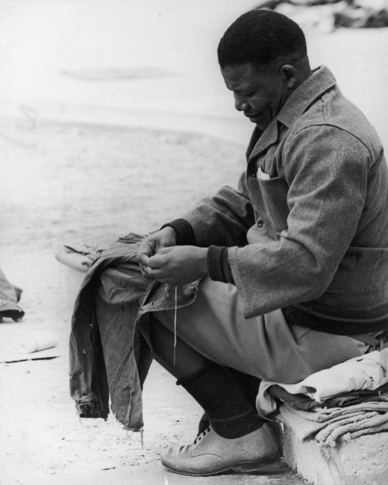 Nelson Mandela sewing prison clothes in the yard of Robben Island prison off Cape Town, 1966