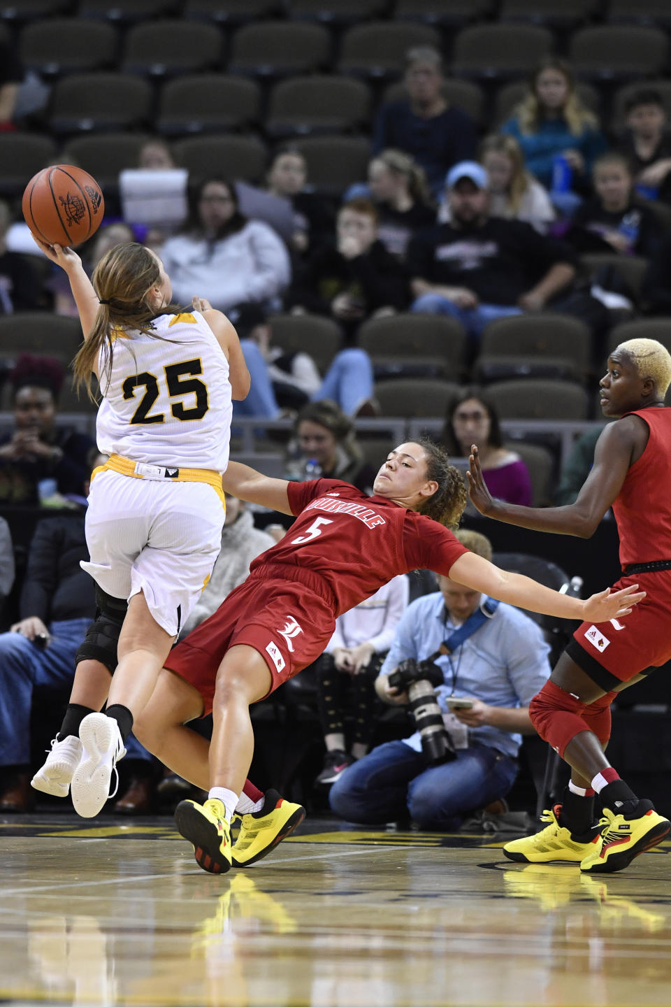 Louisville guard Mykasa Robinson (5) takes a charge from Northern Kentucky guard Ally Niece (25) during the second half of an NCAA college basketball game in Highland Heights, Ky., Sunday, Dec. 8, 2019. Louisville won 85-57. (AP Photo/Timothy D. Easley)