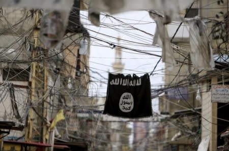 An Islamic State flag hangs amid electric wires over a street in Ain al-Hilweh Palestinian refugee camp, near the port-city of Sidon, southern Lebanon January 19, 2016. REUTERS/Ali Hashisho