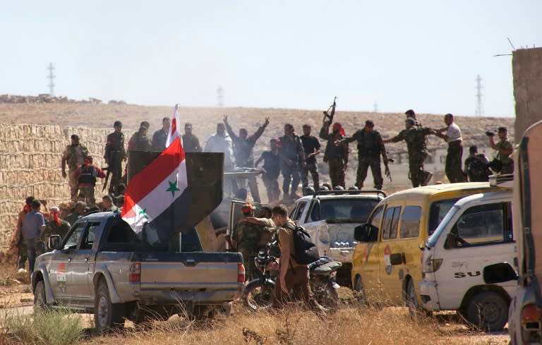 Syrian government forces celebrate in the Palestinian refugee camp of Handarat, north of Aleppo, after they captured the area following multiple Russian air strikes