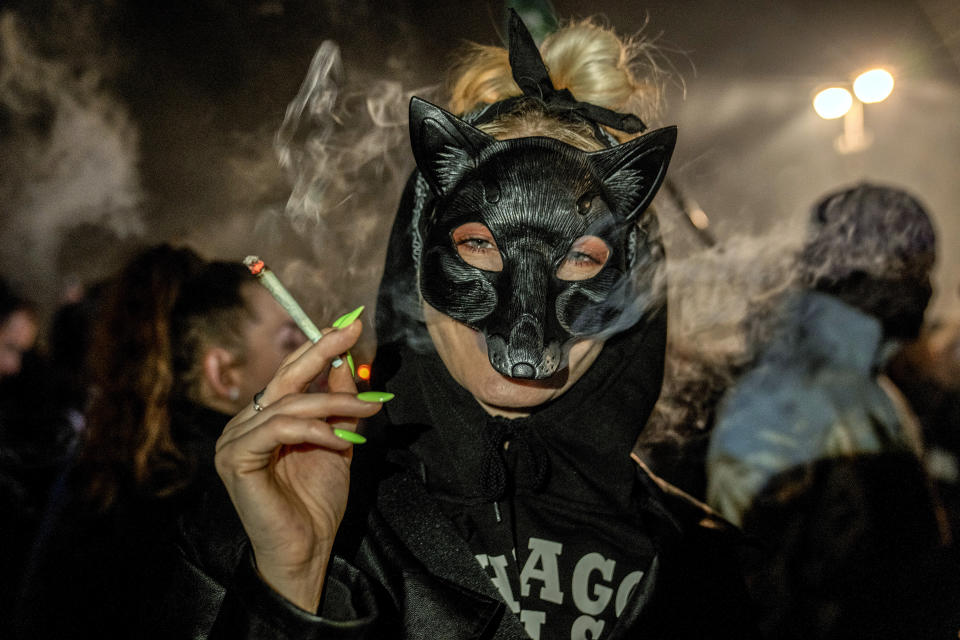 People smoke marijuana in front of the Brandenburg Gate during the 'Smoke-In' event in Berlin, Germany, Monday, April 1, 2024. Starting 1 April, Germany has legalised cannabis for personal use. As per the new law, Adults aged 18 and over will be allowed to carry up to 25 grams of cannabis for their own consumption. (AP Photo/Ebrahim Noroozi)