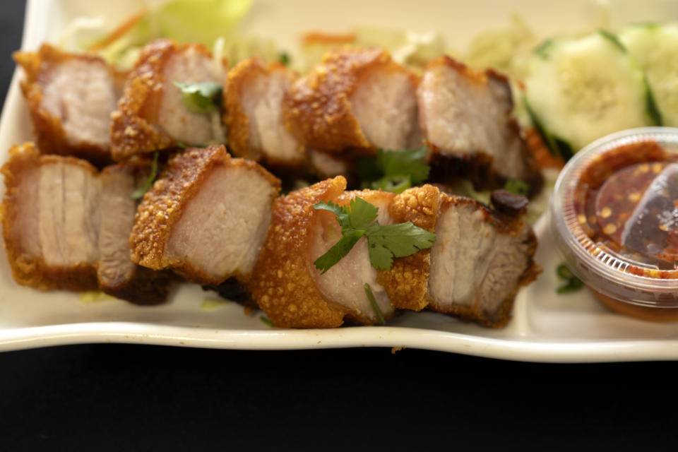 FILE - Crispy Pork Belly is presented at "Love & Thai" restaurant in Fresno, Calif., on Dec. 20, 2023. The Thai restaurant was wrongfully accused of abusing a dog to turn it into meat, a false claim rooted in a racist stereotype. (AP Photo/Richard Vogel, File)