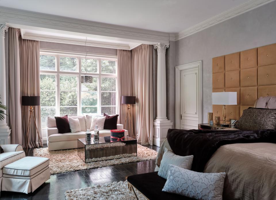 Other than the Michael Amini bed, mirrored coffee table by Bassman Blaine, and some Arteriors lamps, everything in the primary bedroom is custom-made, including the camel-colored leather headboard with gold buttons and trimming.