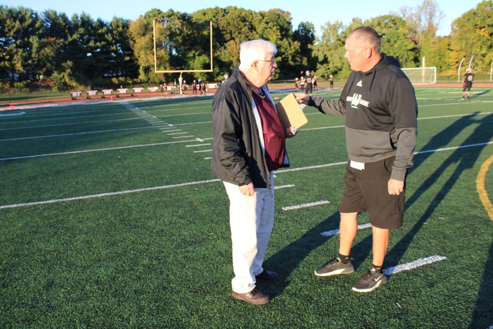 Ernie Mezey talks to Wayne Hills High School football coach Wayne Demikoff as he prepares to announce a game.