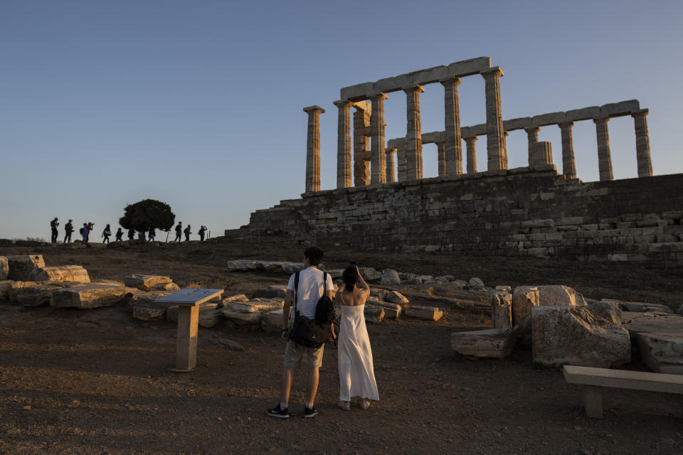 Tourists visit the ancient temple of Poseidon at Cape Sounion, about 70 kilometers (45 miles) south of Athens, on Wednesday, Oct.12, 2022. Greece is on course to beat its annual record for tourism revenue as southern European Union members made a surprise recovery following a two-year travel slump caused by the pandemic. (AP Photo/Petros Giannakouris)