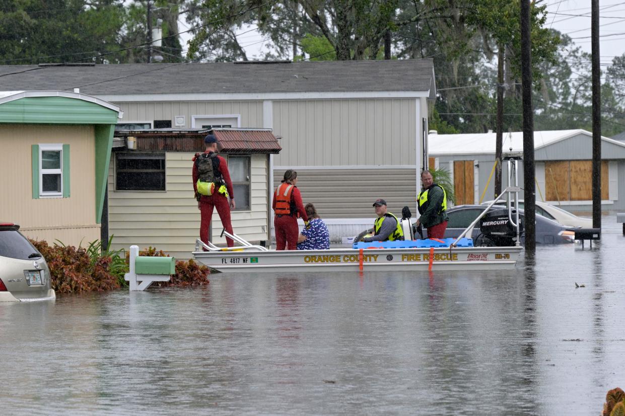 First responders with Orange County Fire Rescue use a boat to rescue a resident in a flooded neighborhood in the aftermath of Hurricane Ian, Thursday, Sept. 29, 2022, in Orlando, Fla. (AP Photo/Phelan M. Ebenhack)