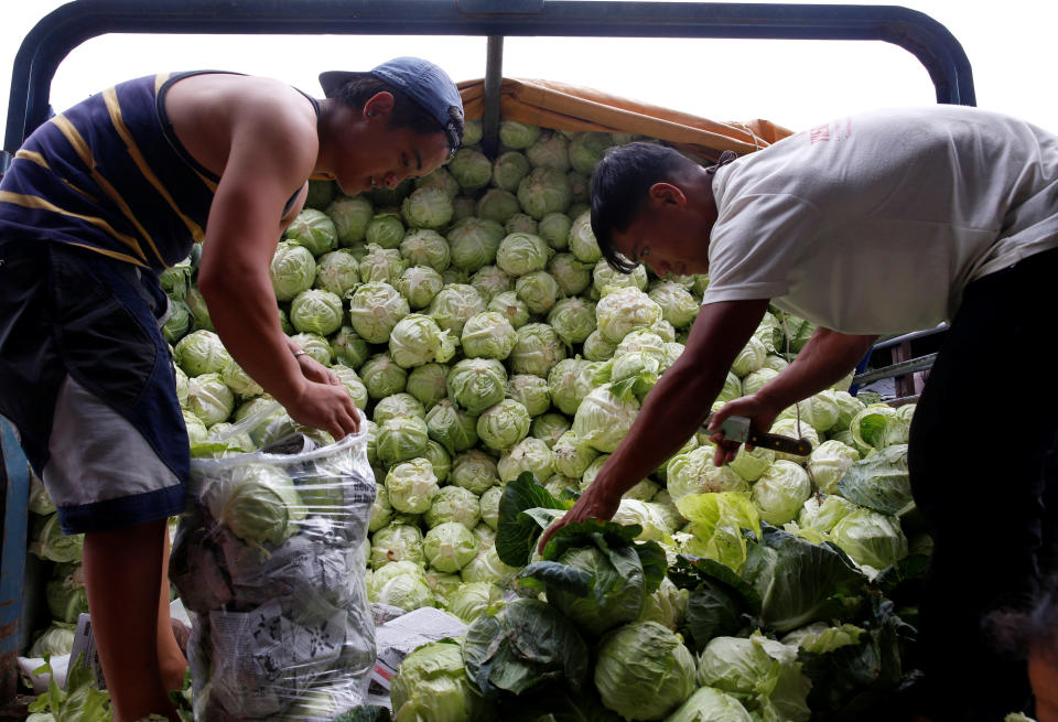 Workers sort cabbages at a truck outside a vegetable market in La Trinidad, Benguet in northern Philippines August 6, 2016. Picture taken August 6, 2016.  REUTERS/Erik De Castro