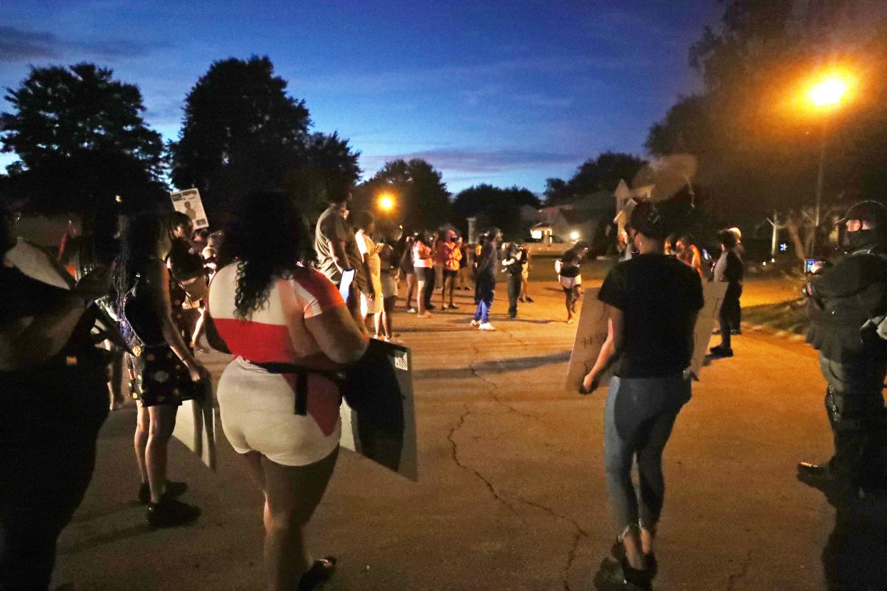 Protesters form a semicircle in front of the home of Charles Brown, Akron's deputy mayor for public safety, on Thursday night to protest the police shooting death of Jayland Walker.