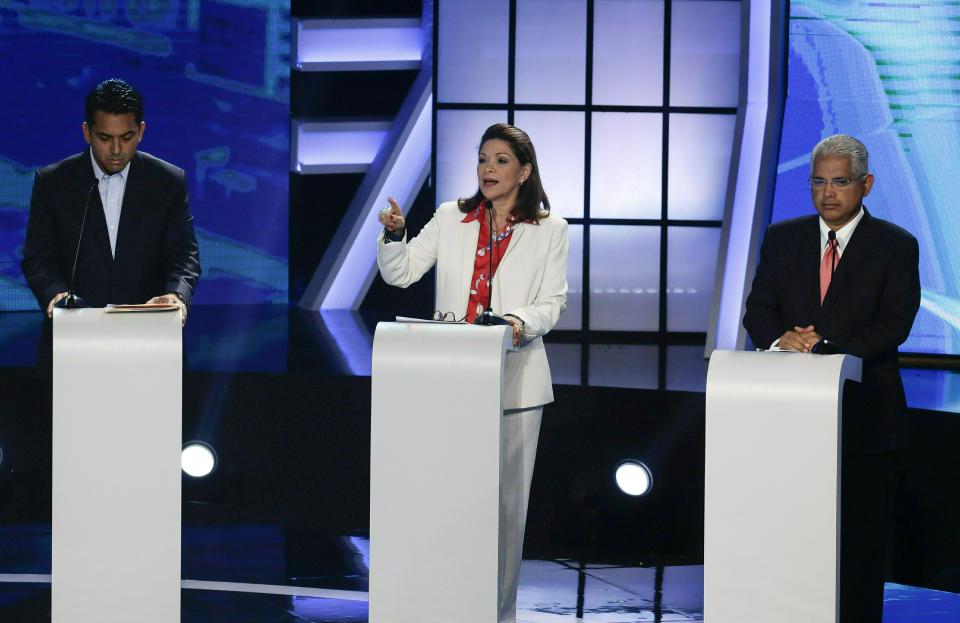 La candidata independiente a la presidencia de Panamá Ana Matilde Gómez habla entre el candidato independiente Ricardo Lombana, a la izquierda, y José Blandon, del Partido Panamenista, durante un debate presidencial televisado y organizado por la Cámara de Comercio Panameña en Ciudad de Panamá, el 10 de abril de 2019 (AP Foto/Arnulfo Franco)