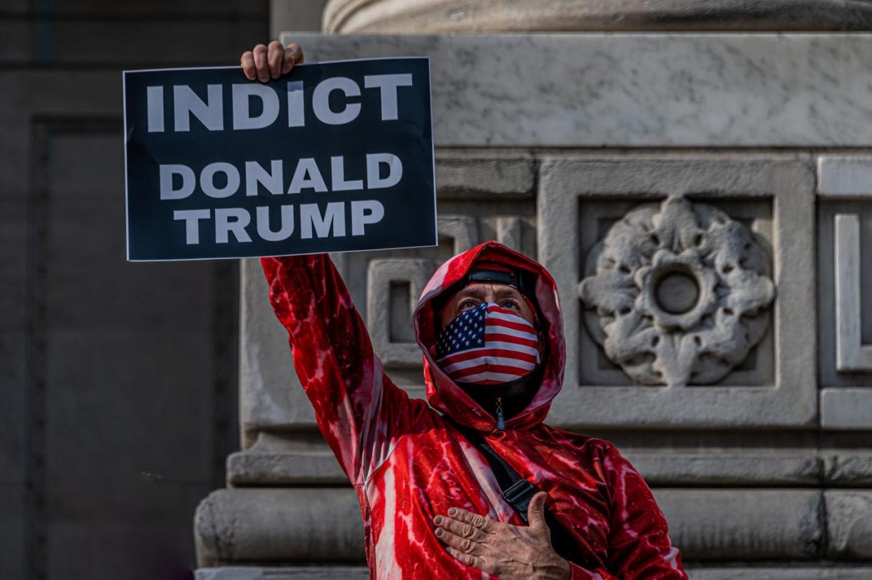 <span class="caption">A man protesting in New York City one year after the violent insurrection in Washington, D.C. </span> <span class="attribution"><a class="link " href="https://www.gettyimages.com/detail/news-photo/participant-holding-a-sign-reading-indict-donald-trump-at-news-photo/1237580013?adppopup=true" rel="nofollow noopener" target="_blank" data-ylk="slk:Erik McGregor/LightRocket via Getty Images;elm:context_link;itc:0;sec:content-canvas">Erik McGregor/LightRocket via Getty Images</a></span>