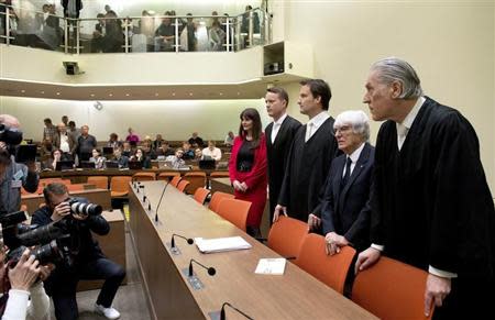 Formula One chief executive Bernie Ecclestone (2nd R) stands with his lawyers Sven Thomas (R) and Norbert Scharf (3rd R) as he arrives in court in Munich April 24, 2014. REUTERS/Michaela Rehle