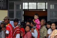 Voters stand in a queue outside a polling station in the constituency where Myanmar opposition leader Aung San Suu Kyi is running in Kawhmu on April 1, 2012