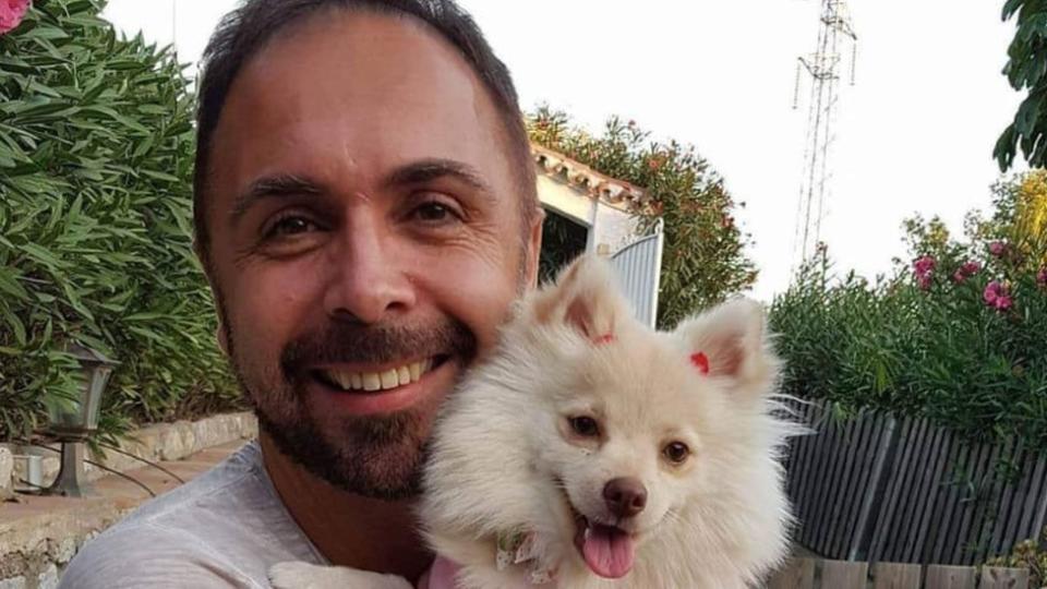 Sean Thweny smiling while holding his dog