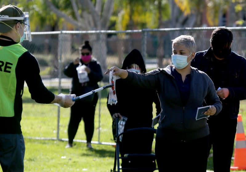 BALDWIN PARK CALIF. - DEC.21, 2020. People submit self-administered COVID-19 tests at a regional pop-up walk-up testing site in Baldwin Park on Monday, Dec. 21, 2020. (Luis Sinco/Los Angeles Times)