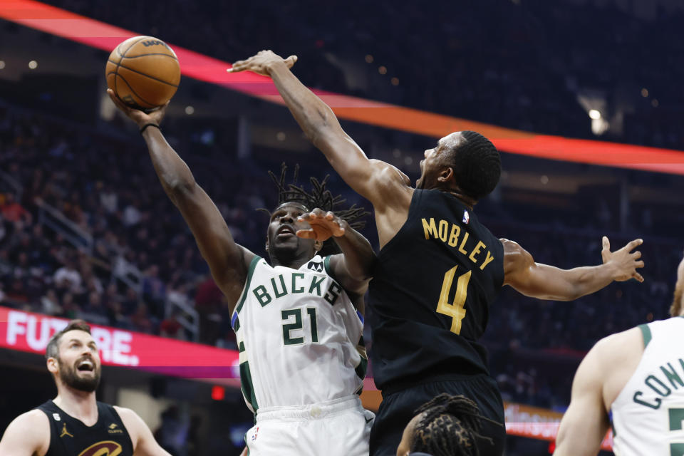 Milwaukee Bucks guard Jrue Holiday (21) shoots against Cleveland Cavaliers forward Evan Mobley (4) during the first half of an NBA basketball game, Saturday, Jan. 21, 2023, in Cleveland. (AP Photo/Ron Schwane)