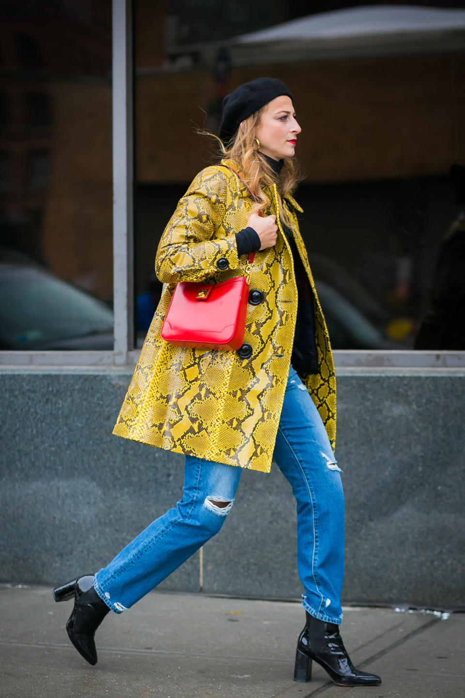 Refinery29’s Annie Georgia Greenberg pairs a rad yellow coat with bright red bag at New York Fashion Week.