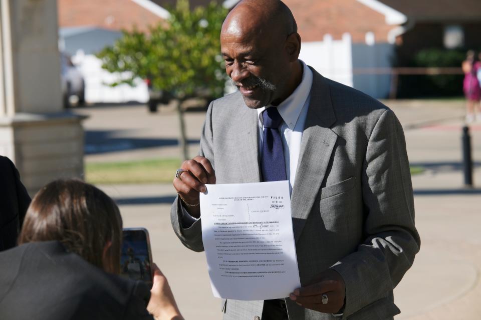 Perry Lott poses Tuesday with the actual court order vacating his conviction.