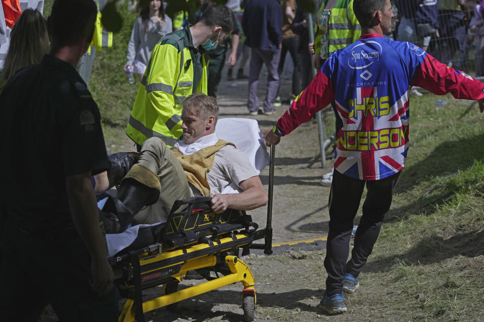A participant receives medical treatment after the Cheese Rolling contest at Cooper's Hill in Brockworth, Gloucestershire, Monday May 29, 2023. The Cooper's Hill Cheese-Rolling and Wake is an annual event where participants race down the 200-yard (180 m) long hill chasing a wheel of double gloucester cheese. (AP Photo/Kin Cheung)