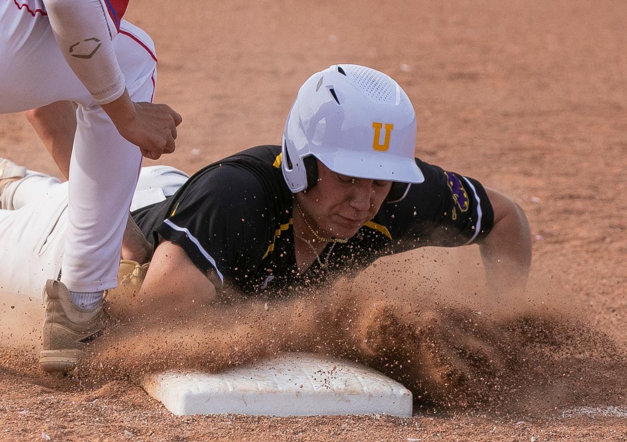 Dirt flies into the face of Unioto's Keegan Snyder (14) as he slides safely back into first base avoiding the pick off from a Zane Trace pitcher in boys baseball at Unioto High School on April 26, 2024, in Chillicothe, Ohio. Unioto defeated Zane Trace 4-1.