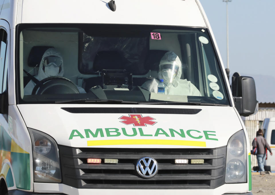 In this photo taken Tuesday, May 19, 2020, paramedics in protective gear drive in an ambulance in Khayelitsha in Cape Town South Africa, With dramatically increased community transmission, Cape Town has become the center of the COVID-19 outbreak in South Africa and the entire continent. (AP Photo/Nardus Engelbrecht)