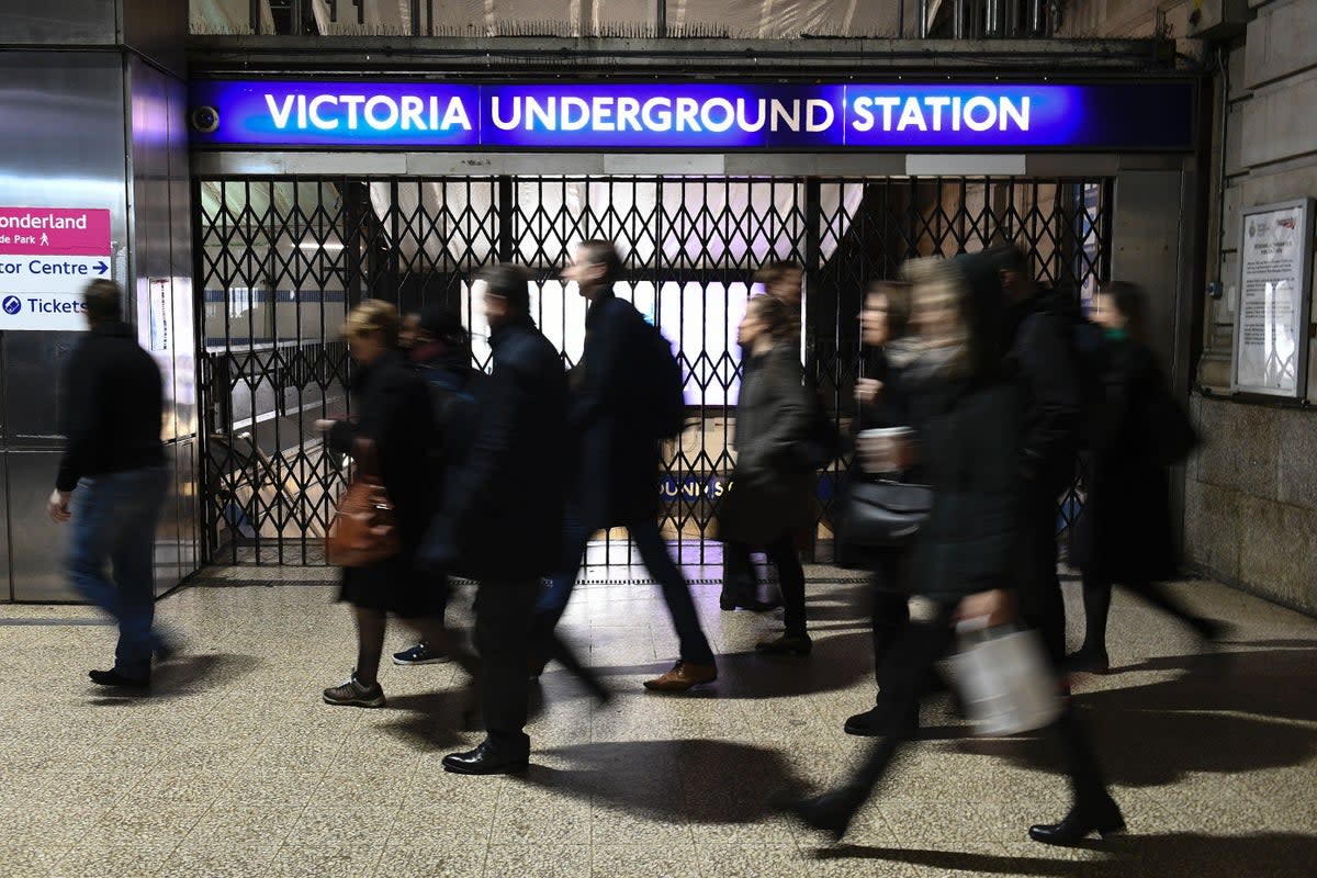 Commuters walk past a shuttered entrance to Victoria Underground Station (Justin Tallis / AFP via Getty Images)