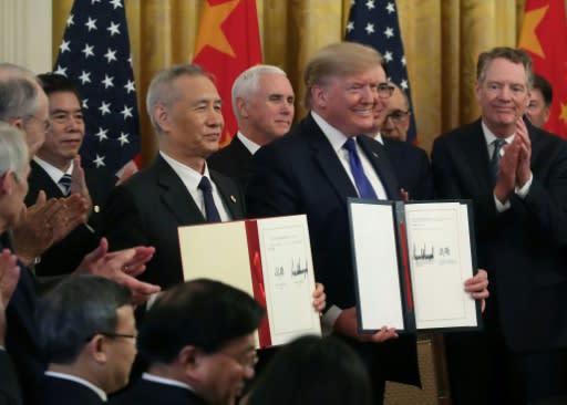 US President Donald Trump (pictured January 15, 2020) and Chinese Vice Premier�Liu�He hold up signed agreements of "phase one" of a trade deal between the two countries