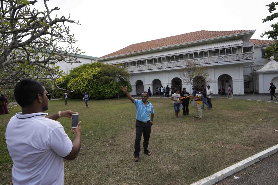 People take photographs at the premises of the prime minister's official residence a day after it was stormed in Colombo, Sri Lanka, Sunday, July 10, 2022. Sri Lanka’s opposition political parties will meet Sunday to agree on a new government a day after the country’s president and prime minister offered to resign in the country’s most chaotic day in months of political turmoil, with protesters storming both officials’ homes and setting fire to one of the buildings in a rage over the nation’s economic crisis. (AP Photo/Eranga Jayawardena)