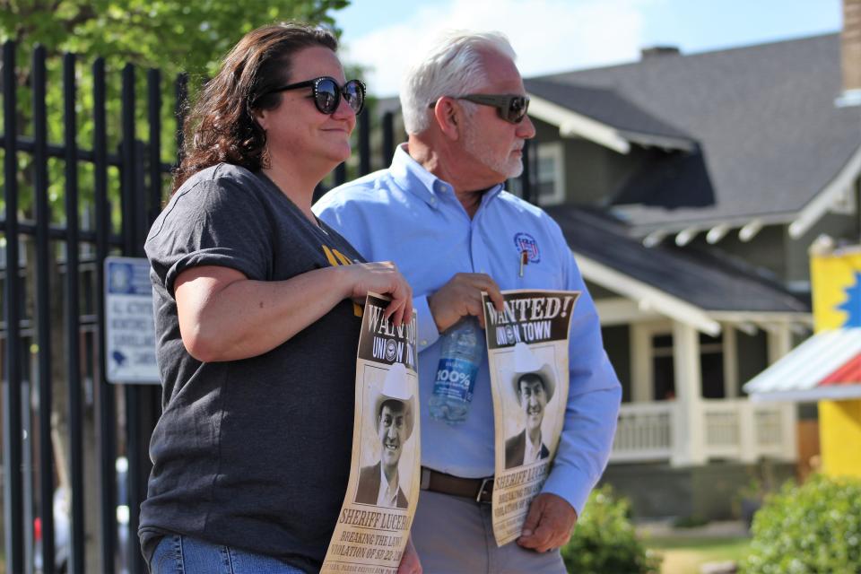 Hilary Glasgow and Vince Champion, regional president of the International Brotherhood of Police Officers, hold signs during a demonstration outside the Pueblo County Sheriff's Office on Wednesday, May 4, 2024.