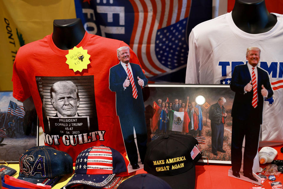 Campaign merchandise for former President Donald Trump, including t-shirts and hats, rest on a display table. (Joe Raedle / Getty Images)