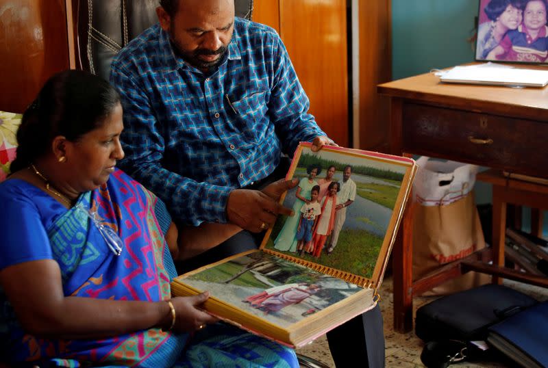 Karibeeran Paramesvaran and his wife Choodamani, who lost three children in the 2004 tsunami, show their family album inside their house that they have turned into a care home for orphaned children in Nagapattinam district in the southern state of Tamil Na