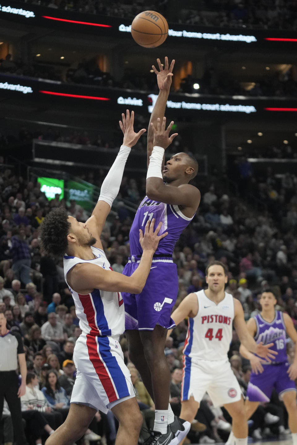 Utah Jazz guard Kris Dunn (11) shoots as Detroit Pistons guard Cade Cunningham, left, defends during the first half of an NBA basketball game Wednesday, Jan. 3, 2024, in Salt Lake City. (AP Photo/Rick Bowmer)