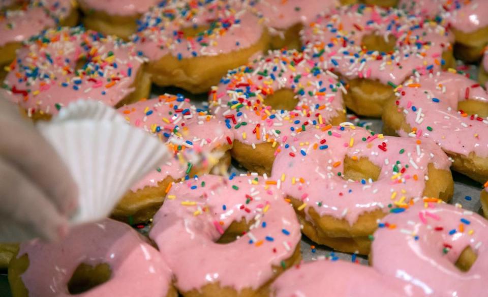 Robin Murphy decorates strawberry sprinkle yeast donuts at Donut Days Bakery on Wednesday, June 3, 2020 in Lexington Kentucky. The bakery usually sees an influx of customers on the first Friday in June in celebration of National Donut Day.