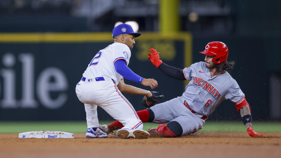 Cincinnati Reds' Jonathan India, right, safely slides into second as Texas Rangers second baseman Marcus Semien, left, tags him during the fourth inning of a baseball game in Arlington, Texas, Saturday, April 27, 2024. (AP Photo/Gareth Patterson)