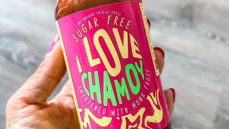 Close-up of a hand holding a bottle of I Love Chamoy