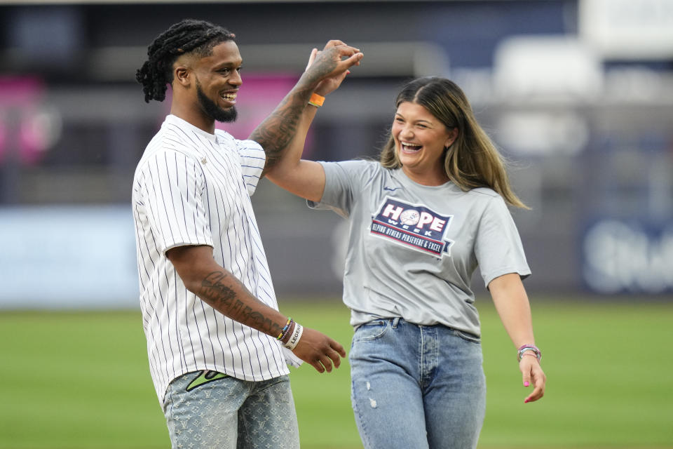 Buffalo Bills defensive back Damar Hamlin, left, and Sarah Taffet, a former Fordham softball player, hight-five after throwing out ceremonial first pitches before a baseball game between the New York Yankees and the Baltimore Orioles, Monday, July 3, 2023, in New York. (AP Photo/Frank Franklin II)